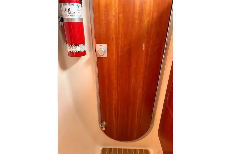Slide: The Image of Fire extinguisher and wooden door inside 2003 PDQ 34 Power Catamaran. - 47