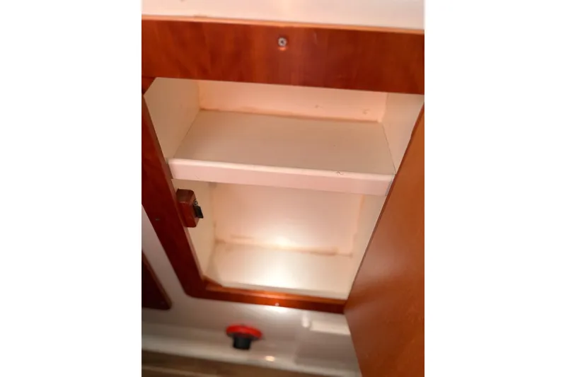 Slide: The Image of Open wooden cabinet inside 2003 PDQ 34 Power Catamaran, showcasing interior shelving. - 46