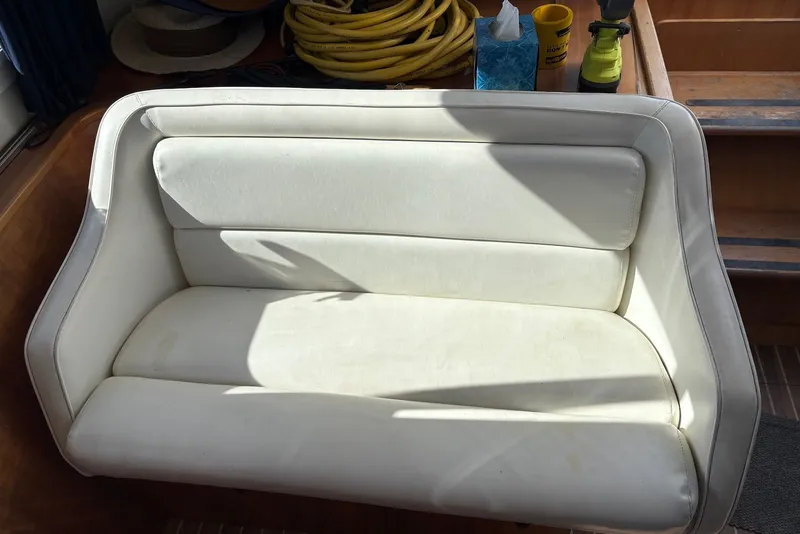 Slide: The Image of White cushioned seat on 2003 PDQ 34 Power Catamaran, with accessories in background. - 21