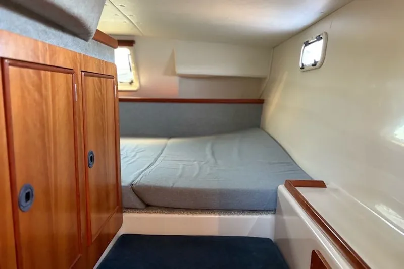 Slide: The Image of Interior cabin of 2003 PDQ 34 Power Catamaran with wooden cabinets and cozy bed. - 36