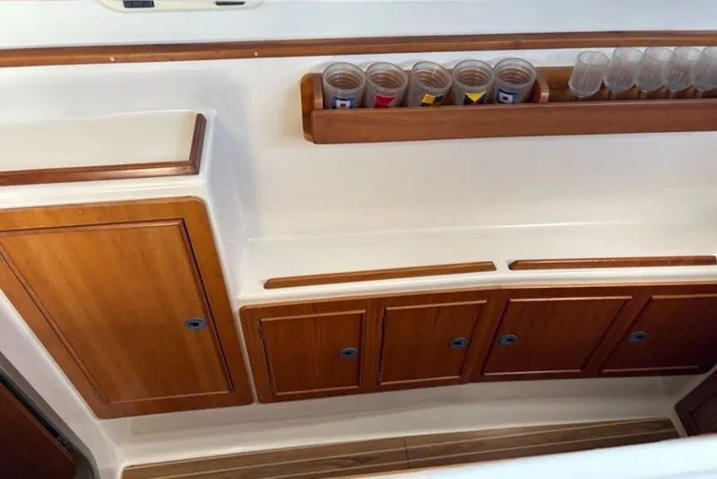 Slide: The Image of Interior of 2003 PDQ 34 Power Catamaran with wooden cabinets and glass holders. - 44