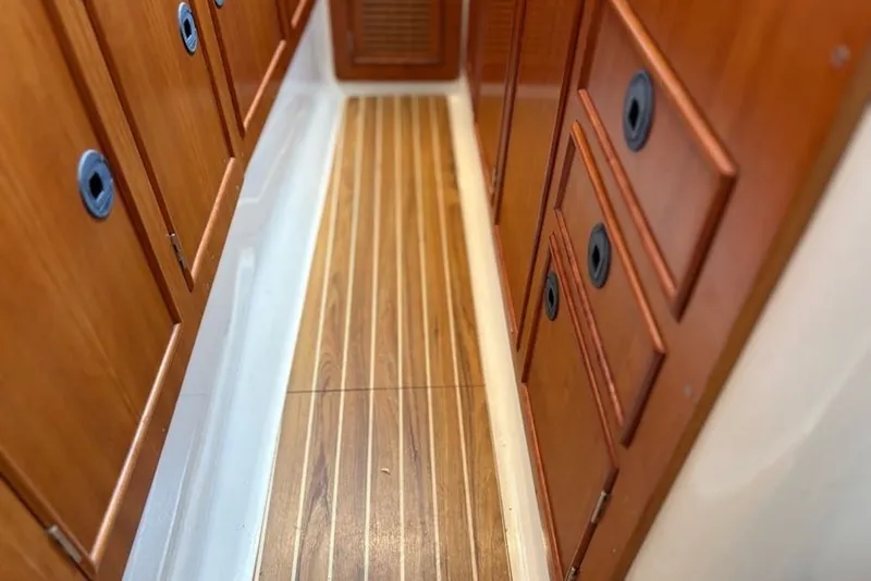 Slide: The Image of Wood-paneled hallway inside 2003 PDQ 34 Power Catamaran, featuring sleek cabinetry and flooring. - 43