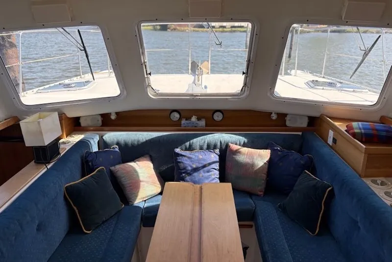 Slide: The Image of Interior of 2003 PDQ 34 Power Catamaran with blue seating and colorful cushions. - 22