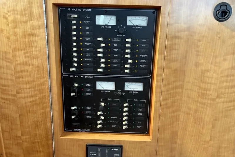 Slide: The Image of Electrical panel on a 2003 PDQ 34 Power Catamaran, featuring 12V DC and 120V AC systems. - 26