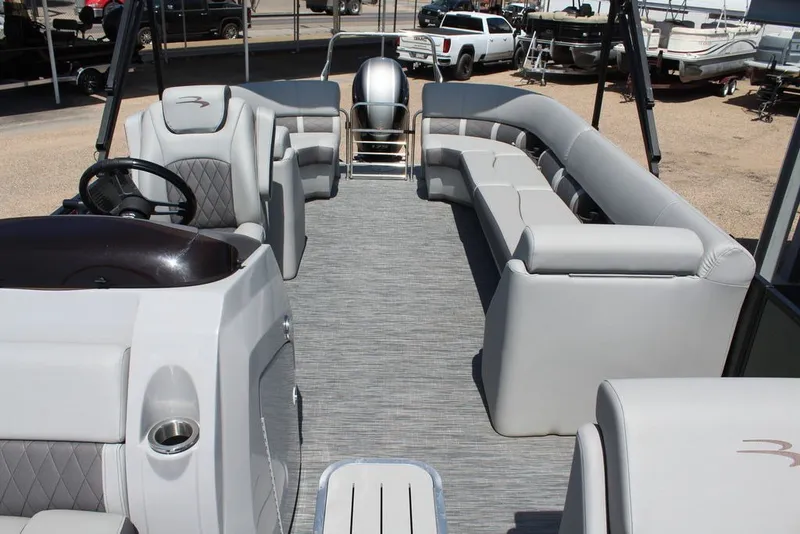 Slide: The Image of 2023 Bennington 23 LSR pontoon boat interior with plush seating and steering console. - 9
