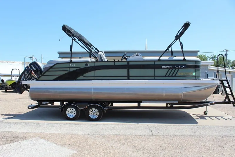 Slide: The Image of 2023 Bennington 23 LSR pontoon boat on trailer, parked outdoors. - 3