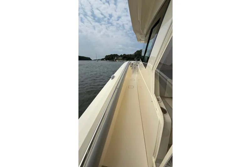 Slide: The Image of Side view of a 2021 Scout 530 LXF boat on the water under a cloudy sky. - 52