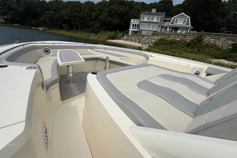 Slide: The Image of Luxurious 2021 Scout 530 LXF boat interior with seating and table, near waterfront homes. - 48