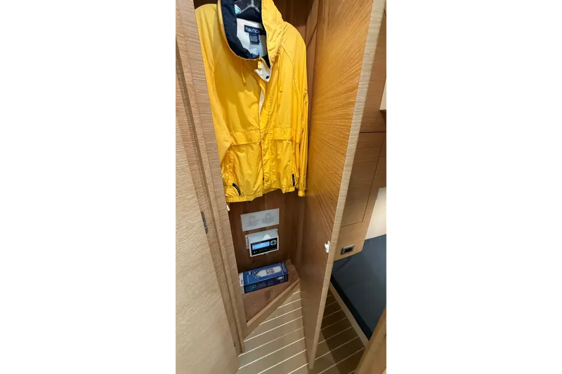 Slide: The Image of Yellow jacket hanging in a wooden closet on a 2021 Scout 530 LXF boat. - 43