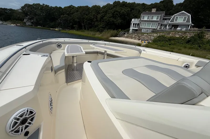Slide: The Image of 2021 Scout 530 LXF luxury boat interior with seating and table, near waterfront homes. - 46