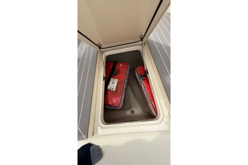 Slide: The Image of Open storage compartment on 2021 Scout 530 LXF boat with red life jackets. - 51