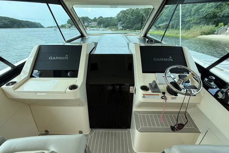 Slide: The Image of 2021 Scout 530 LXF helm with dual Garmin displays and steering wheel, overlooking serene waters. - 19