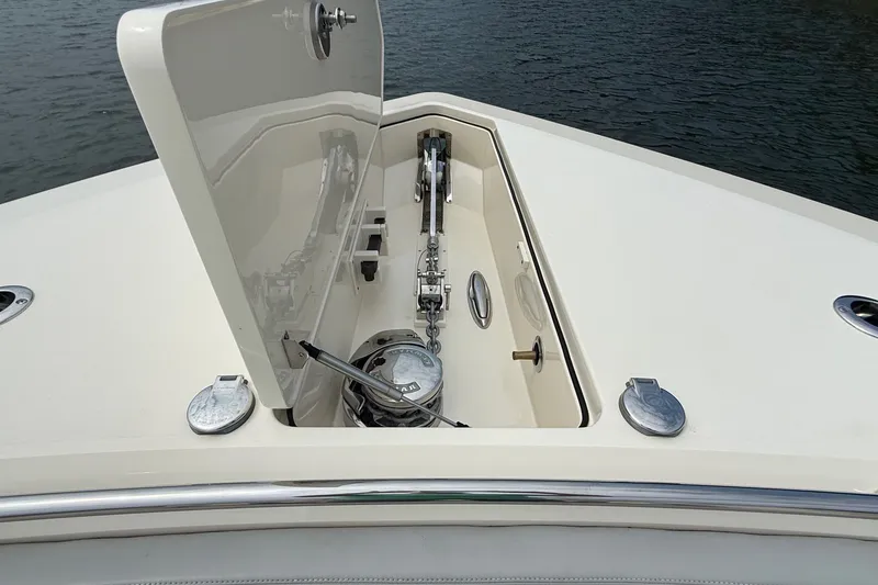 Slide: The Image of Anchor compartment of 2021 Scout 530 LXF boat, open hatch, on calm water. - 49