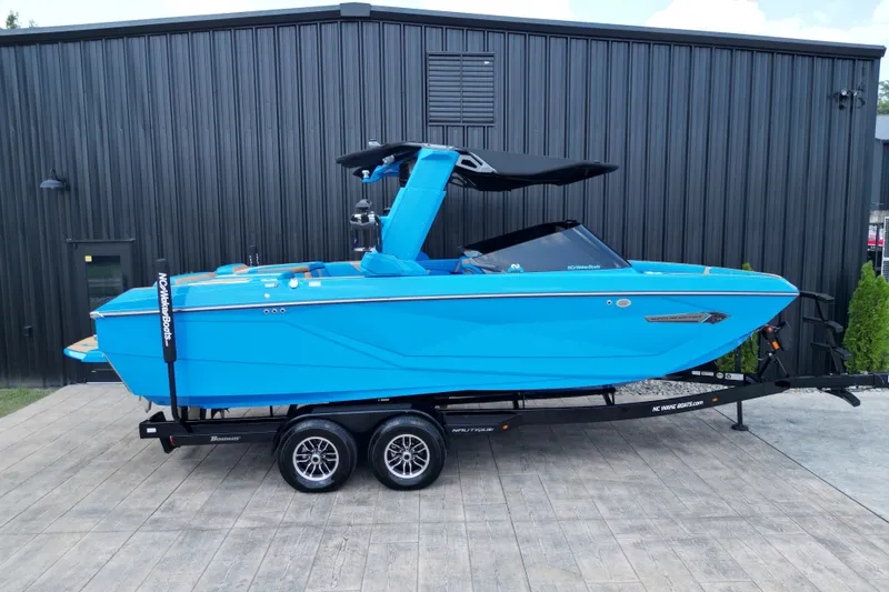 Slide: The Image of 2024 Nautique Super Air Nautique G23 boat in vibrant blue on a trailer. - 18