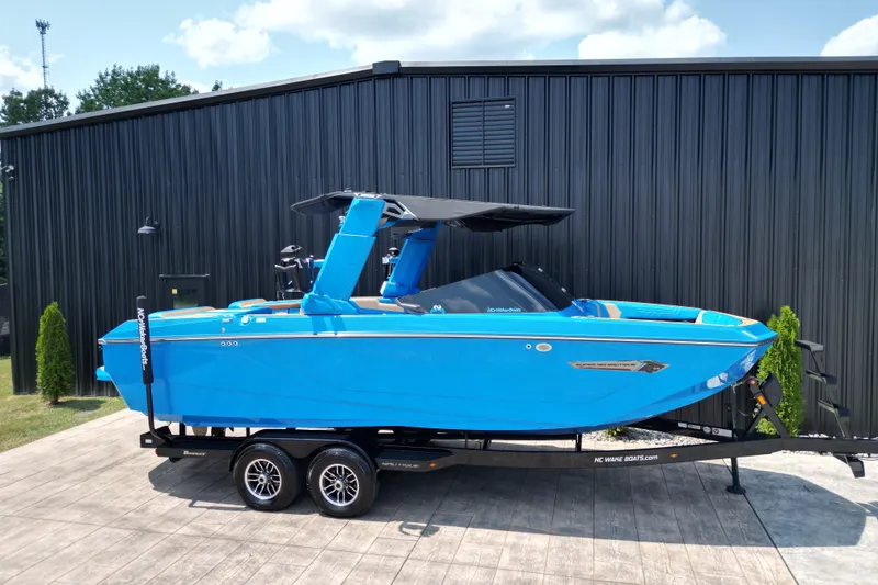 The Image of 2024 Nautique Super Air Nautique G23 boat in vibrant blue on a trailer. - 1