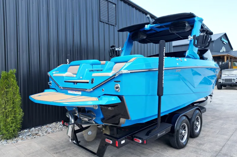 Slide: The Image of 2024 Nautique Super Air Nautique G23 boat in vibrant blue on a trailer. - 14
