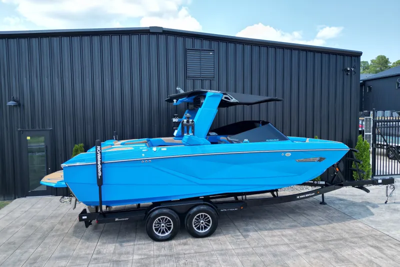Slide: The Image of 2024 Nautique Super Air Nautique G23 boat in vibrant blue on trailer, parked outdoors. - 20