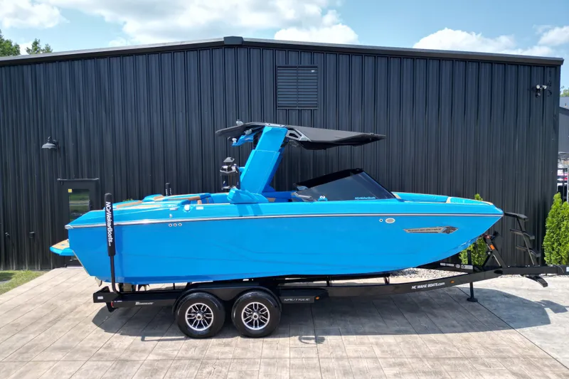 Slide: The Image of 2024 Nautique Super Air Nautique G23 boat in vibrant blue on a trailer. - 21