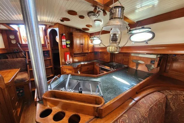 Slide: The Image of Interior of 1979 Hans Christian 38 Traditional sailboat with wooden cabinetry and vintage lanterns. - 13