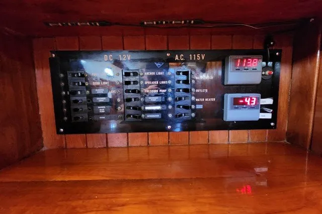 Slide: The Image of Electrical panel on a 1979 Hans Christian 38 Traditional boat, featuring DC 12V and AC 115V systems. - 36