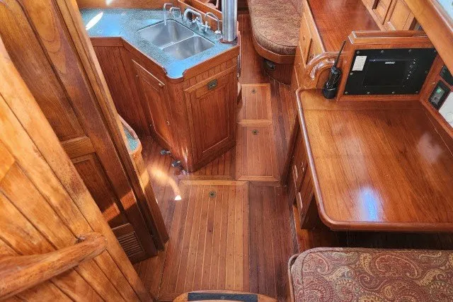 Slide: The Image of 1979 Hans Christian 38 Traditional yacht interior with wooden cabinetry and compact kitchen area. - 5