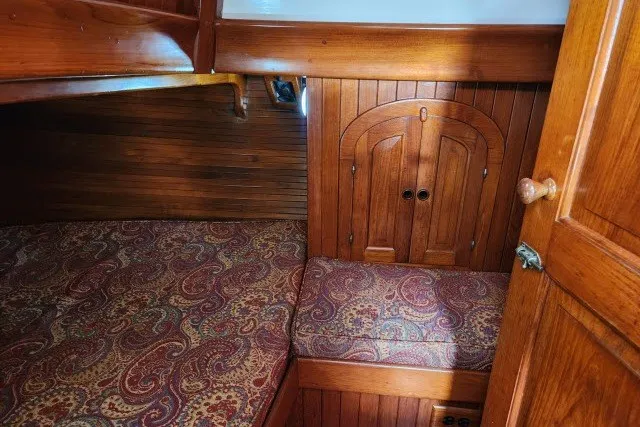 Slide: The Image of Cozy cabin interior of 1979 Hans Christian 38 Traditional sailboat with wood paneling and patterned cushions. - 9
