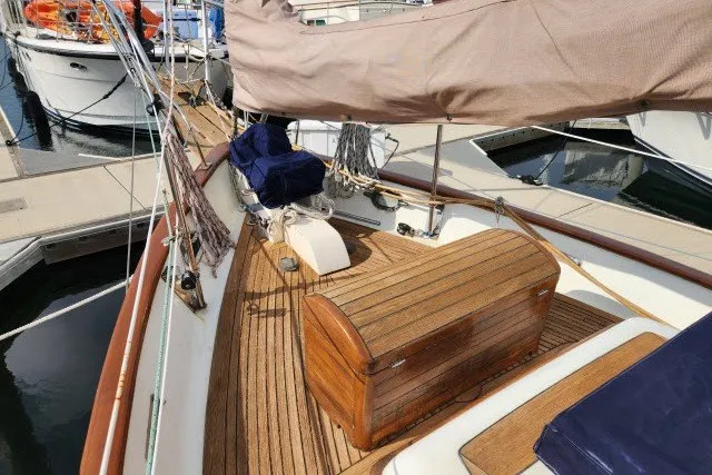 Slide: The Image of 1979 Hans Christian 38 Traditional sailboat with wooden deck and covered sails at a marina. - 53