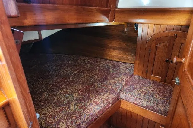 Slide: The Image of Cozy cabin interior of 1979 Hans Christian 38 Traditional sailboat with wood paneling and patterned cushions. - 7