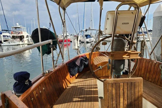Slide: The Image of 1979 Hans Christian 38 Traditional sailboat cockpit with wooden deck, docked at marina. - 47
