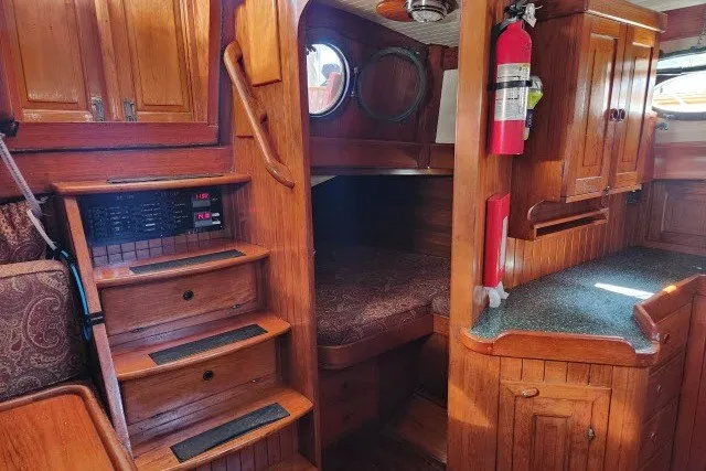 Slide: The Image of 1979 Hans Christian 38 Traditional yacht interior with wooden cabinetry and cozy sleeping area. - 8