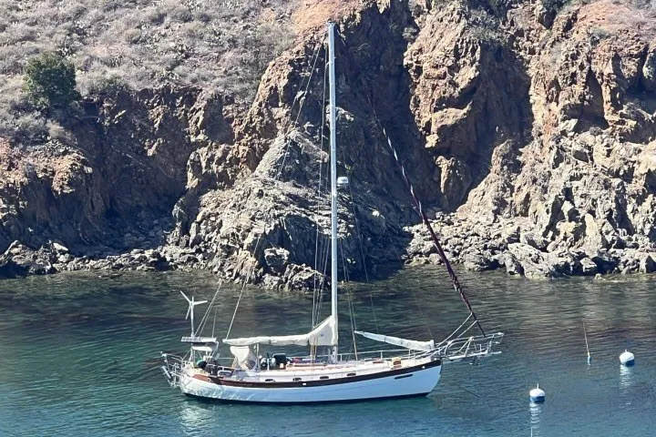 Slide: The Image of Sailboat anchored near rocky coastline, Hans Christian 38 Traditional, 1979 model. - 3