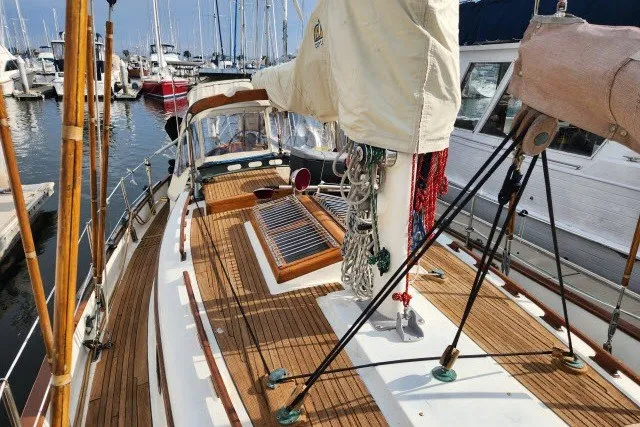 Slide: The Image of 1979 Hans Christian 38 Traditional sailboat docked in a marina, showcasing wooden deck and rigging. - 52