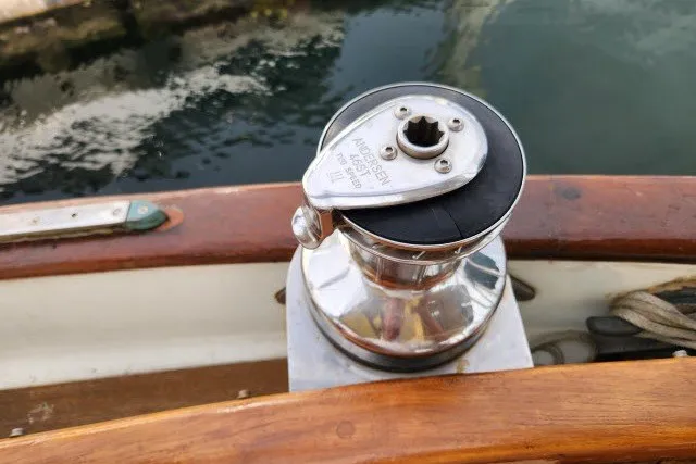 Slide: The Image of Chrome winch on 1979 Hans Christian 38 Traditional sailboat deck, near water. - 56