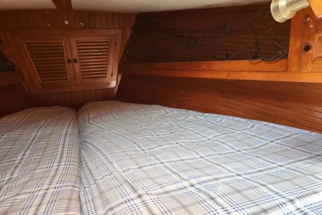 Slide: The Image of Cozy cabin interior of 1979 Hans Christian 38 Traditional sailboat with plaid bedding. - 28