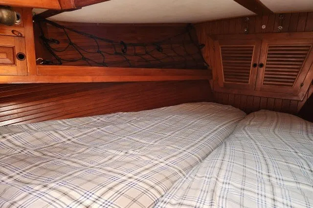 Slide: The Image of Cozy cabin interior of 1979 Hans Christian 38 Traditional sailboat with wooden finish and plaid bedding. - 27