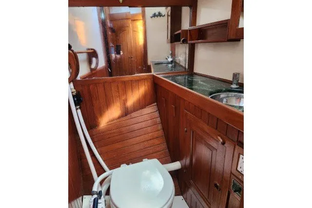 Slide: The Image of 1979 Hans Christian 38 Traditional yacht bathroom with wooden cabinetry and compact sink. - 31