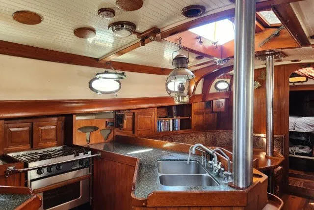 Slide: The Image of Interior of 1979 Hans Christian 38 Traditional sailboat with wooden cabinetry and modern kitchen amenities. - 6