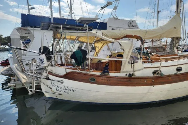 Slide: The Image of 1979 Hans Christian 38 Traditional sailboat docked in a marina, named Heure Bleue. - 45