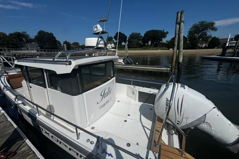 Slide: The Image of 2016 Axopar 28 Cabin boat docked, featuring sleek design and powerful outboard motor. - 4