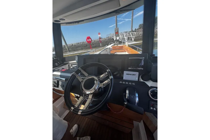 Slide: The Image of Interior view of 2016 Axopar 28 Cabin boat cockpit with steering wheel and controls. - 9