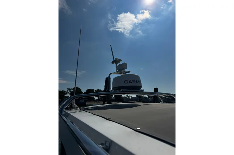 Slide: The Image of 2016 Axopar 28 Cabin boat with Garmin radar under a clear blue sky. - 11