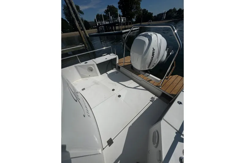 Slide: The Image of 2016 Axopar 28 Cabin boat with outboard motor, docked by a wooden pier. - 5