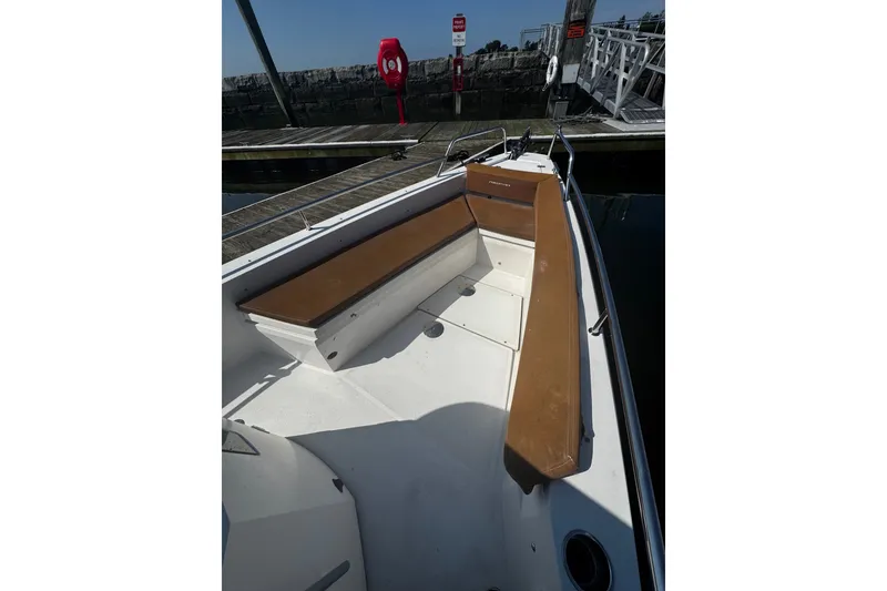 Slide: The Image of 2016 Axopar 28 Cabin boat interior with brown seating, docked at marina. - 3