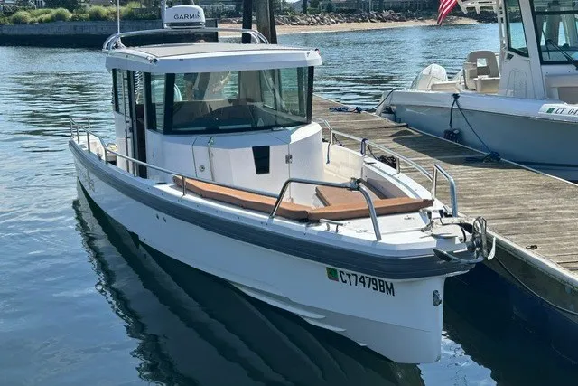 The Image of 2016 Axopar 28 Cabin boat docked in a marina, featuring sleek design and modern amenities. - 1