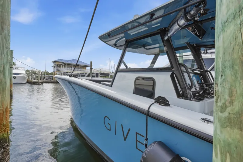 Slide: The Image of 2025 Yellowfin 42 Offshore boat docked at marina, blue sky background. - 41