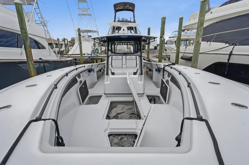 Slide: The Image of 2025 Yellowfin 42 Offshore boat docked, showcasing spacious deck and seating area. - 20