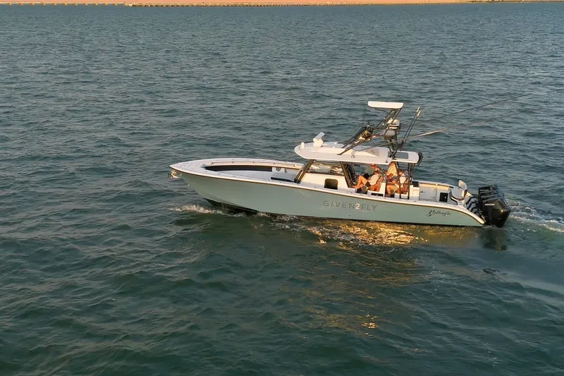 Slide: The Image of 2025 Yellowfin 42 Offshore boat cruising on open water at sunset. - 15