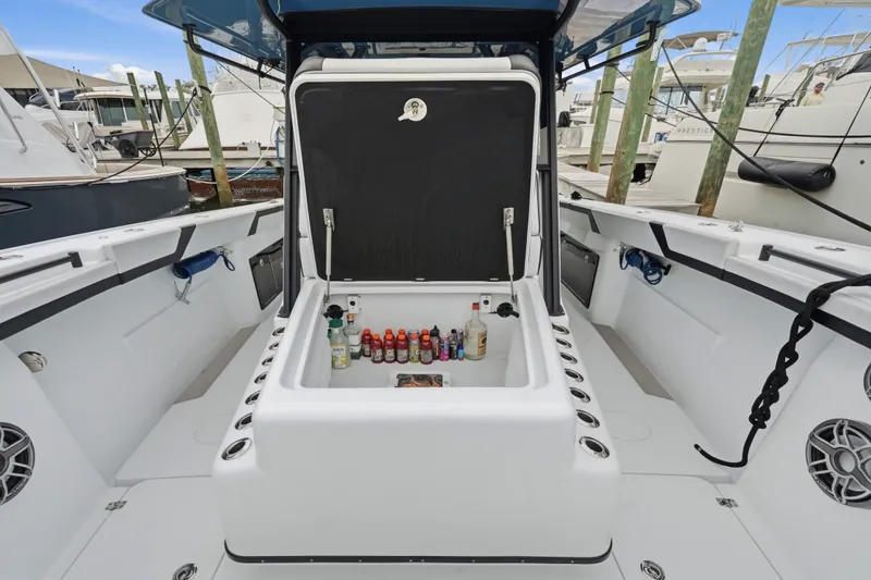 Slide: The Image of 2025 Yellowfin 42 Offshore boat with open storage compartment, docked at marina. - 32
