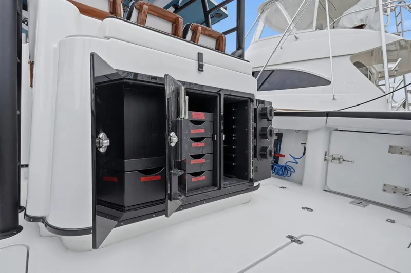 Slide: The Image of Storage compartments on a 2025 Yellowfin 42 Offshore boat, featuring organized tackle boxes. - 59