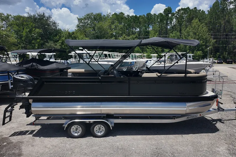 Slide: The Image of 2027 Viaggio V22S pontoon boat on trailer, parked outdoors under a cloudy sky. - 1